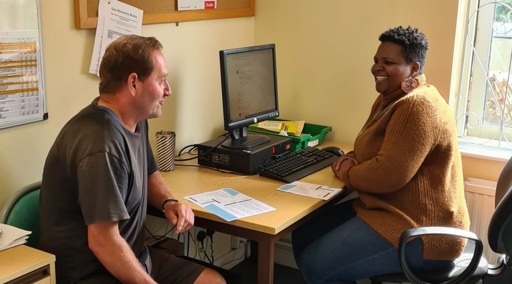 man and woman talking at a desk