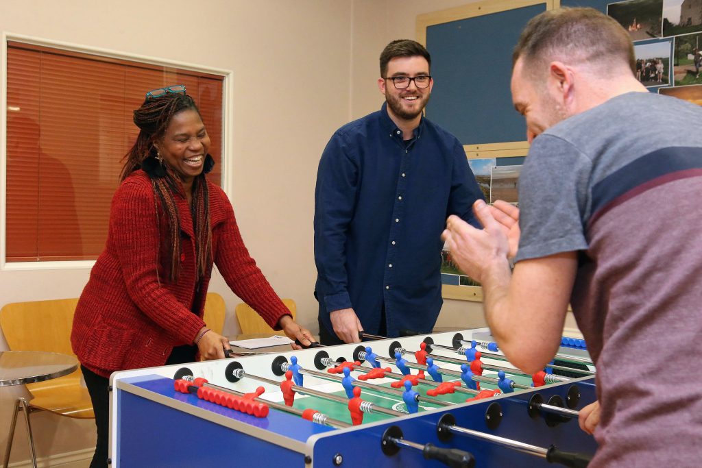 people playing table football and laughing