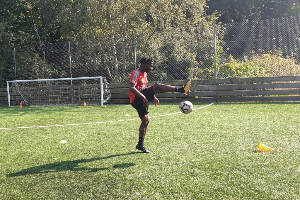 boy kicking a football around