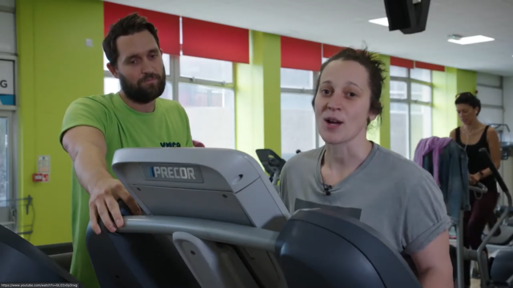 woman on a treadmill with instructor next to her